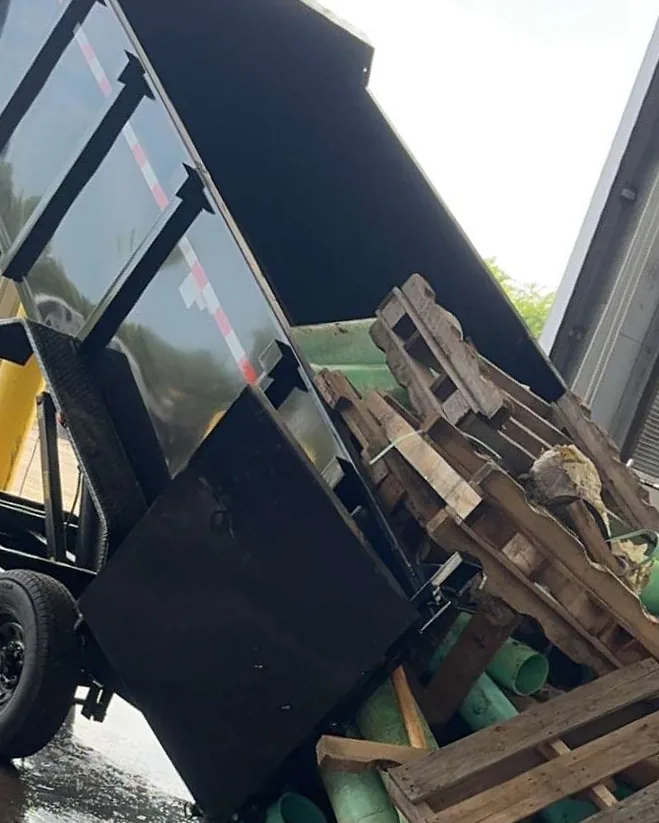 Dump trailer tipped, unloading pipe and pallets