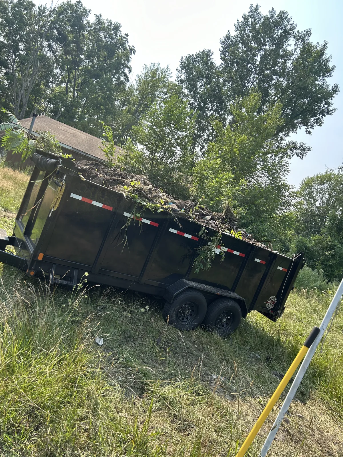 Dump trailer loaded with soil and brush